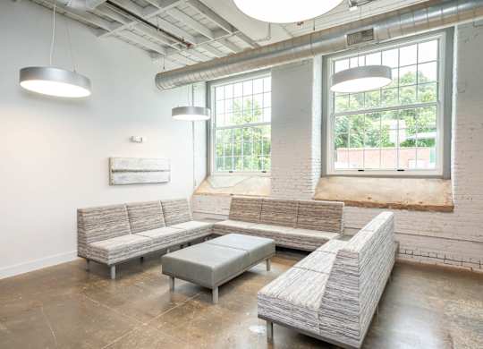 Converse Mill Lofts Luxury Apartments Living Room with Three Couches and an ottoman