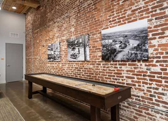 A room with a brick wall and a billiard table.