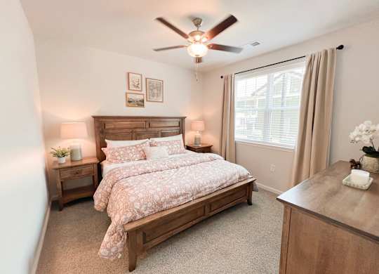 Pet-Friendly Luxury Apartments In Boiling Springs, SC - Grande At Geyser Falls - Carpeted Bedroom Featuring A Large Bed And A Ceiling Fan