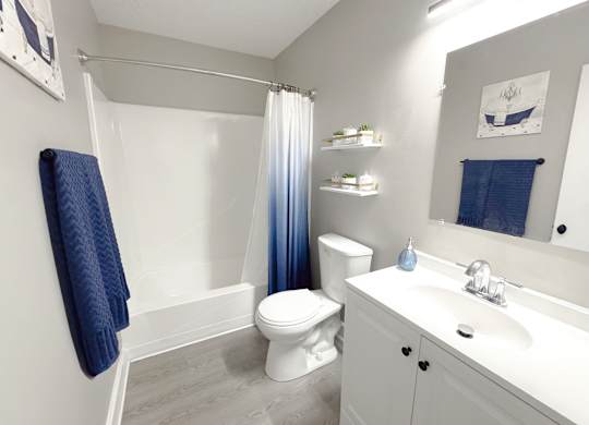 Reserve at Hillcrest model bathroom with a blue shower curtain and blue towel