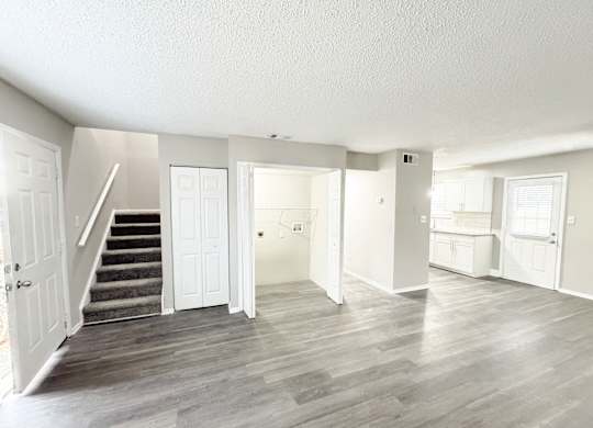 Reserve at Hillcrest living room with LVT flooring, washer and dryer hookups, bathroom, kitchen, closet and carpeted stairs.
