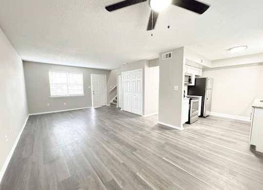 Reserve at Hillcrest living room with LVT flooring, washer and dryer hookups, bathroom, kitchen, closet and carpeted stairs.