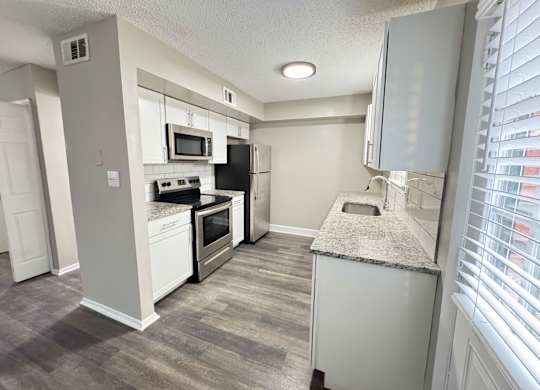 Reserve at Hillcrest Townhomes kitchen with granite countertops, white cabinetry and stainless steel appliances