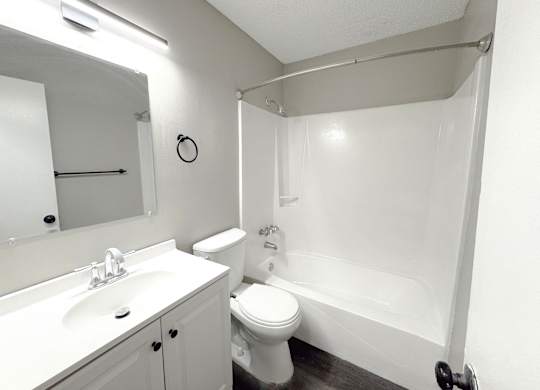 Reserve at Hillcrest Townhomes bathroom with bath/shower, toilet, and white sink with stainless steel faucet
