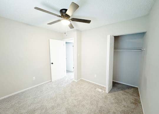 Reserve at Hillcrest upstairs bedroom with carpet, closet, a ceiling fan and light.