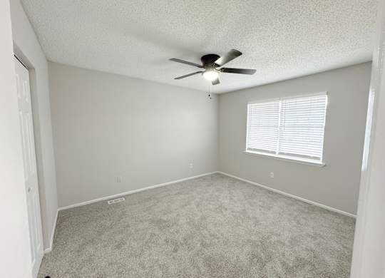 Reserve at Hillcrest Townhomes bedroom with carpet, window, closet, and ceiling fan with light