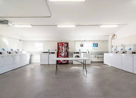 Reserve at Hillcrest Townhomes laundry room with soda machine and lone folding table