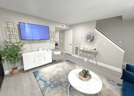 Reserve at Hillcrest model unit staged living room with TV, LVT Flooring, and furniture.