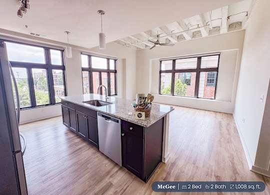 A kitchen with a black countertop and a refrigerator.