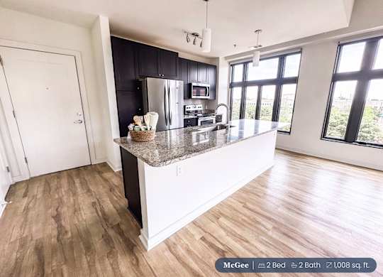 A kitchen with a large island and a view of the city.