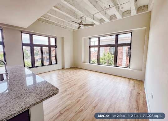 A room with a ceiling fan and two windows.