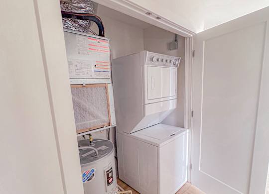 A small kitchen with a fridge, a freezer, and a water filter system.