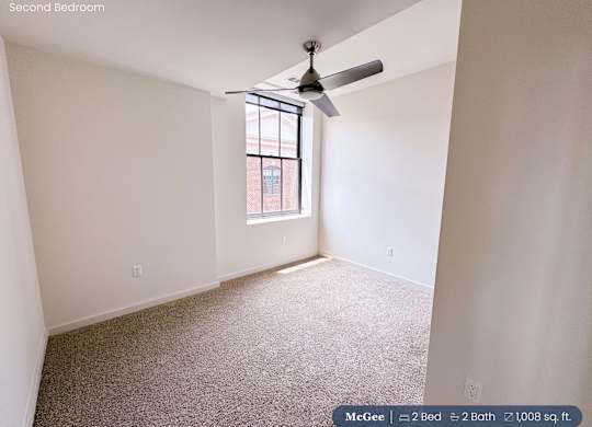 A second bedroom with a fan and a window.