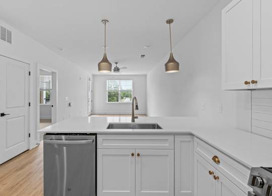 A kitchen with white cabinets and a black countertop.