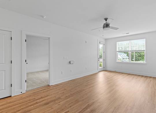 A room with a ceiling fan and a window.