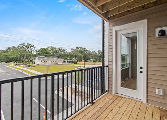 A balcony with a black railing and a white door.