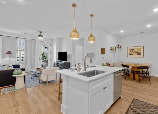 A kitchen with a white island and wooden floors.
