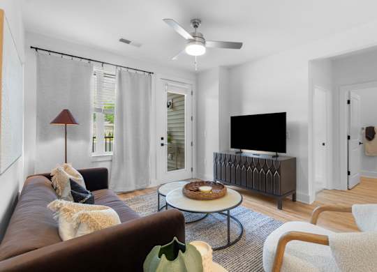 A living room with a brown couch and a dog on it.