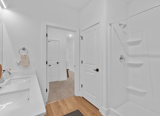 A white bathroom with a sink, mirror, and stairs.