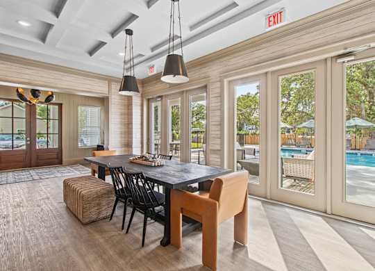 A dining room with a pool in the background.