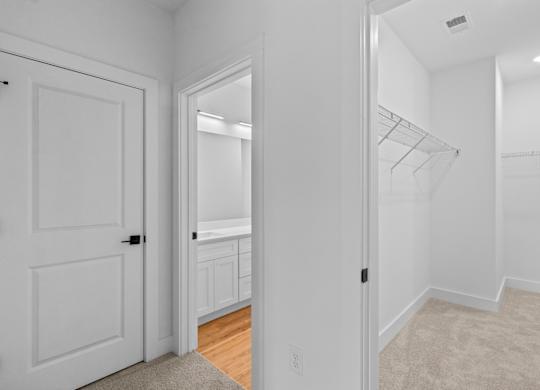 A white room with a door and a closet.