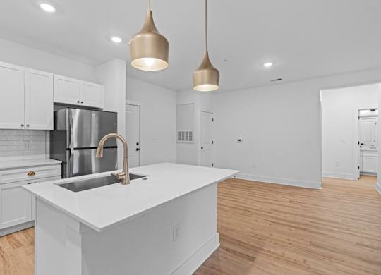 A modern kitchen with a white island and stainless steel appliances.