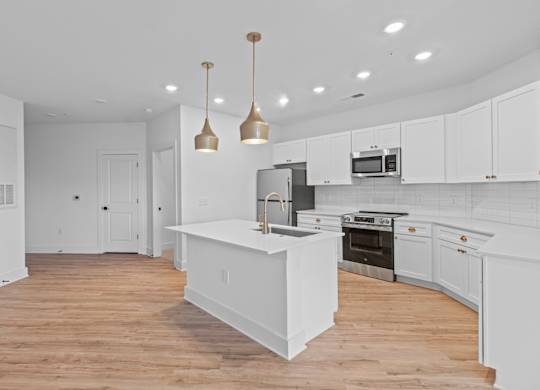 A kitchen with white cabinets and a wooden island.