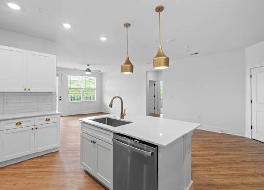 A modern kitchen with white cabinets and a large island.