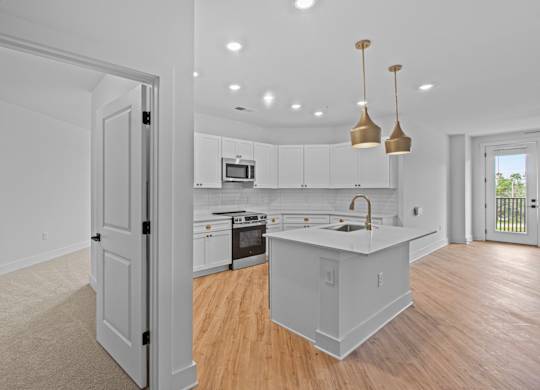 A kitchen with white cabinets and a sink.