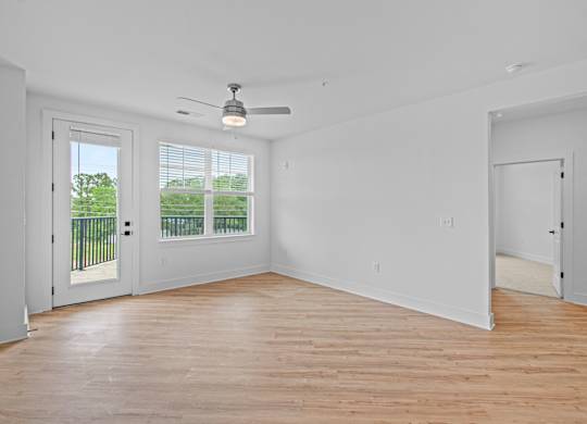 A room with a ceiling fan and a sliding glass door.