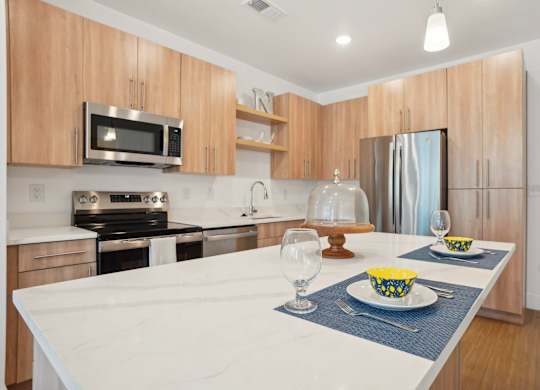 A modern kitchen with a white countertop and wooden cabinets.