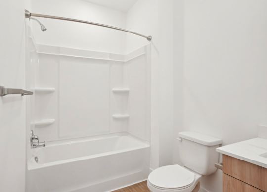 A white bathroom with a toilet, sink, and bathtub.