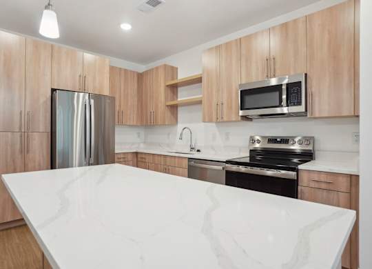 A kitchen with a white counter top and wooden cabinets.