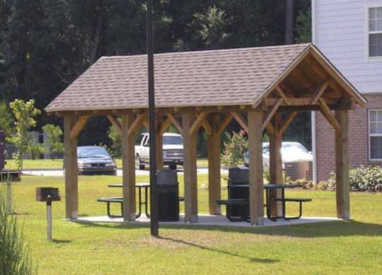 a man sitting on a picnic table in a pavilion