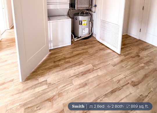 A small room with a white door open to a kitchen area.