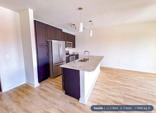 A kitchen with a sink and a refrigerator.