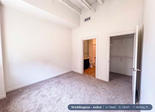 A bedroom with a bed, a bathroom, and a closet.