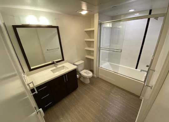 Bathroom with a toilet, sink, mirror, and shower/bathtub.