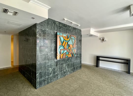 Lobby with emerald colored tile wall with abstract painting