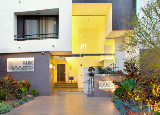 Front entry of apartment building with plants and lighting