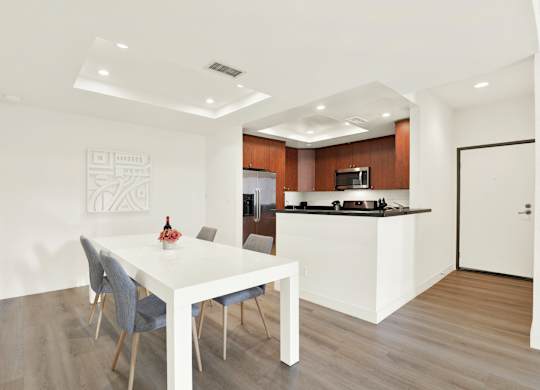 A modern dining room with a white table and grey chairs at Twelve One Ten Rochester, California
