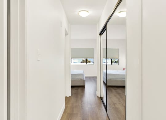 A long hallway with a mirror on the wall at Twelve One Ten Rochester, Los Angeles, CA 90025