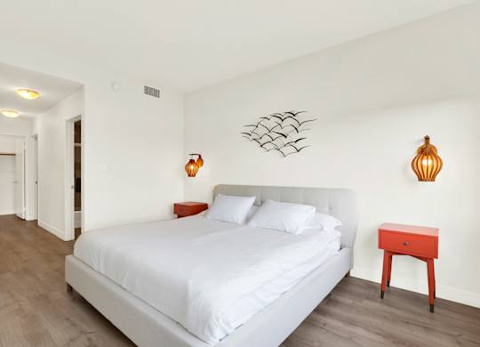 A bedroom with a white bed and a red stool at Twelve One Ten Rochester, California 90025
