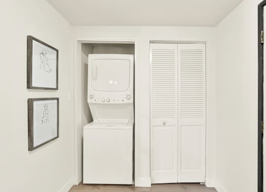 A white washing machine and dryer in a small laundry room at Twelve One Ten Rochester, Los Angeles, CA