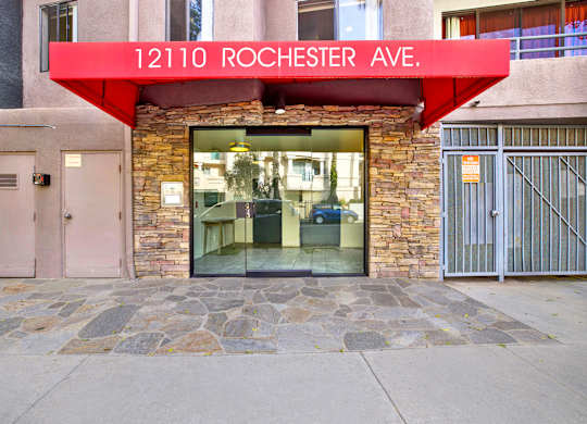 The front of a building with a red awning that says 12110 Rochester Ave at Twelve One Ten Rochester, California 90025