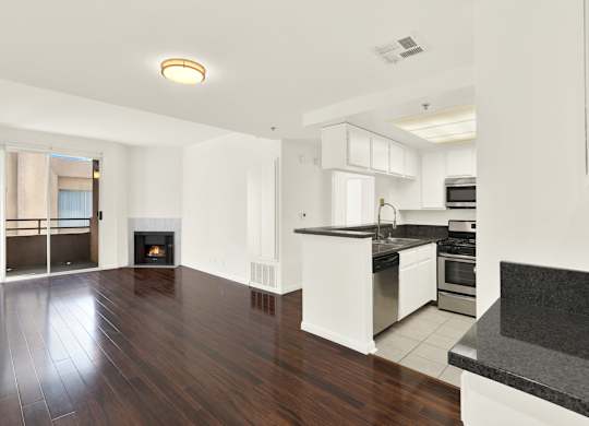 A modern kitchen with white cabinets and a black countertop at Peach Tree Court, Los Angeles