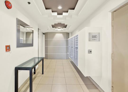 A long hallway with a glass table and a mirror on the wall at Peach Tree Court, California 90024
