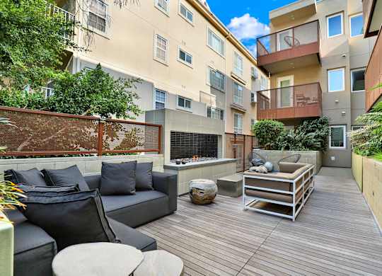 A patio with a black couch and a wooden table at The Urbanpolitan, California