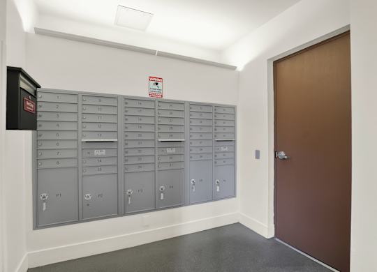 A row of mailboxes are lined up against a wall at The Urbanpolitan, Los Angeles, California