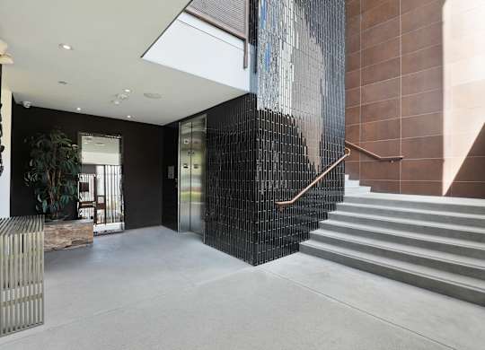 A staircase with a metal railing and a wall with a picture of a man on it at The Urbanpolitan, California